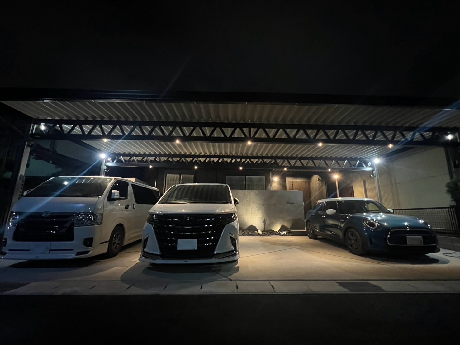 夜を美しく彩る4台用ブラックカーポート ― ダウンライトで高級感あふれるライティング空間