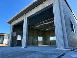 大型倉庫・大型車庫施工事例｜ステンカラーフレーム×シルバー外壁で堅牢かつ機能的な法人向けガレージ