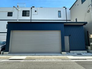 ネイビーブルー外壁が映えるおしゃれなガレージ施工事例｜電動シャッター付き車庫