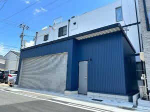 ネイビーブルー外壁が映えるおしゃれなガレージ施工事例｜電動シャッター付き車庫