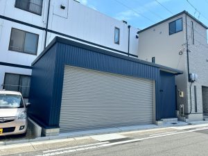 ネイビーブルー外壁が映えるおしゃれなガレージ施工事例｜電動シャッター付き車庫