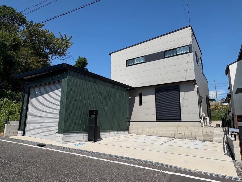モスグリーンのガルバリウム外壁が映えるオシャレな電動シャッター付き車庫<愛知県半田市>