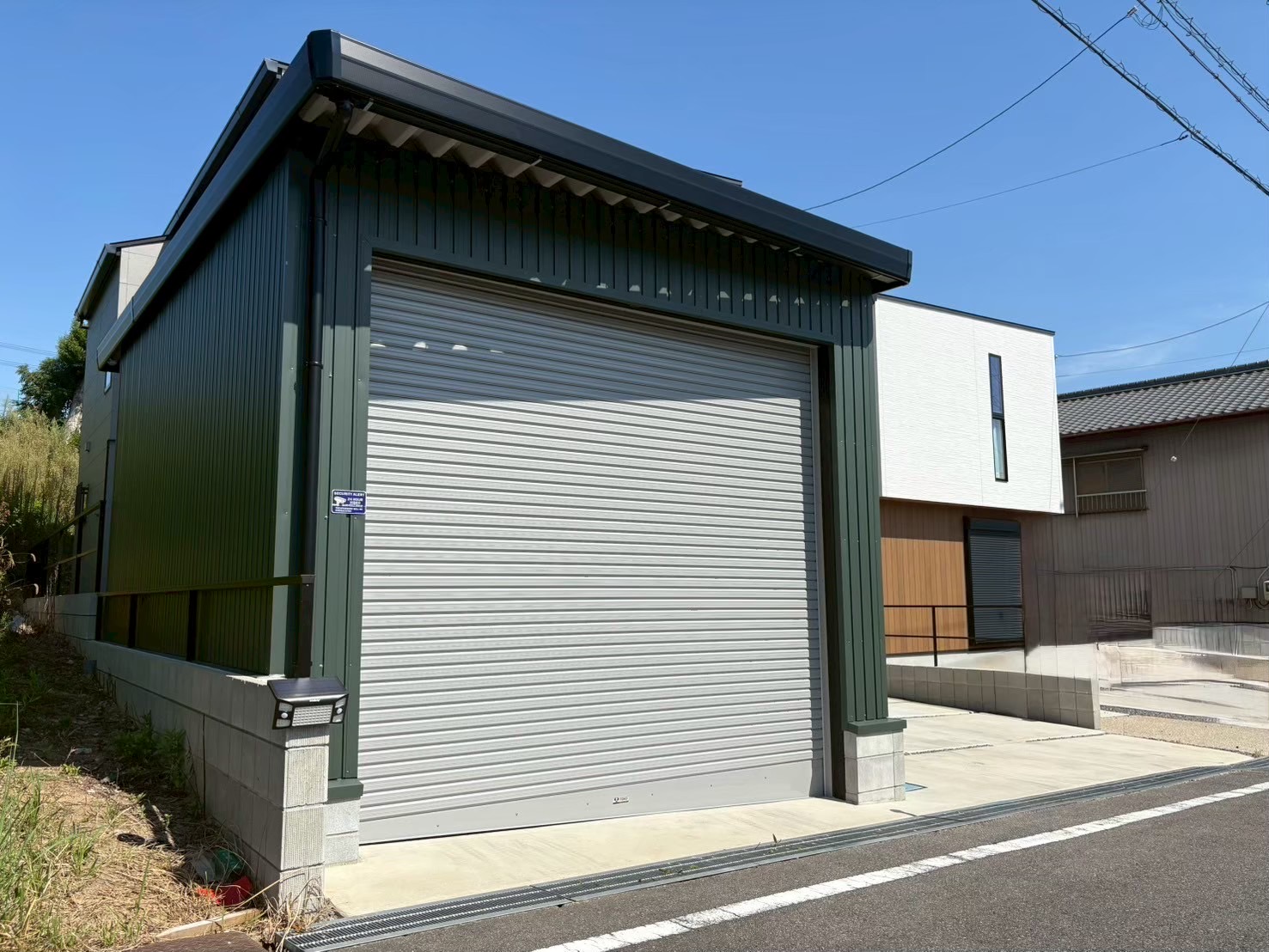 モスグリーンのガルバリウム外壁が映えるオシャレな電動シャッター付き車庫<愛知県半田市>